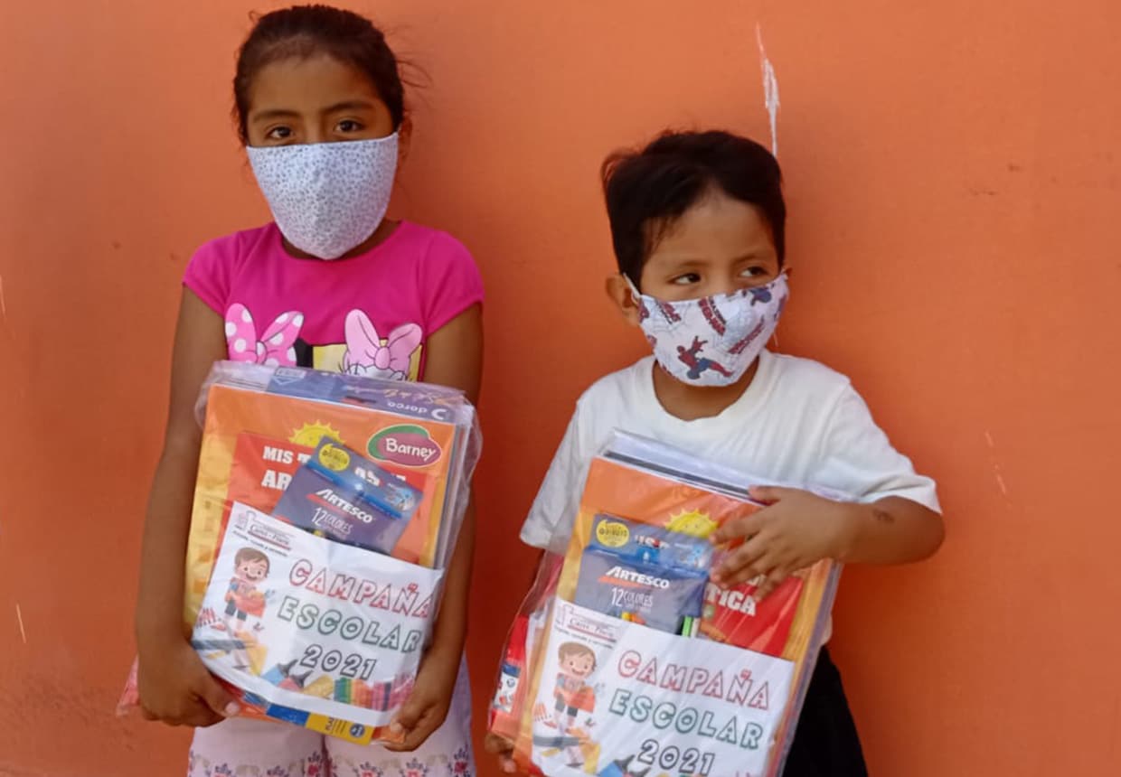 Niños de Piura muestran el material escolar que se les entregó.