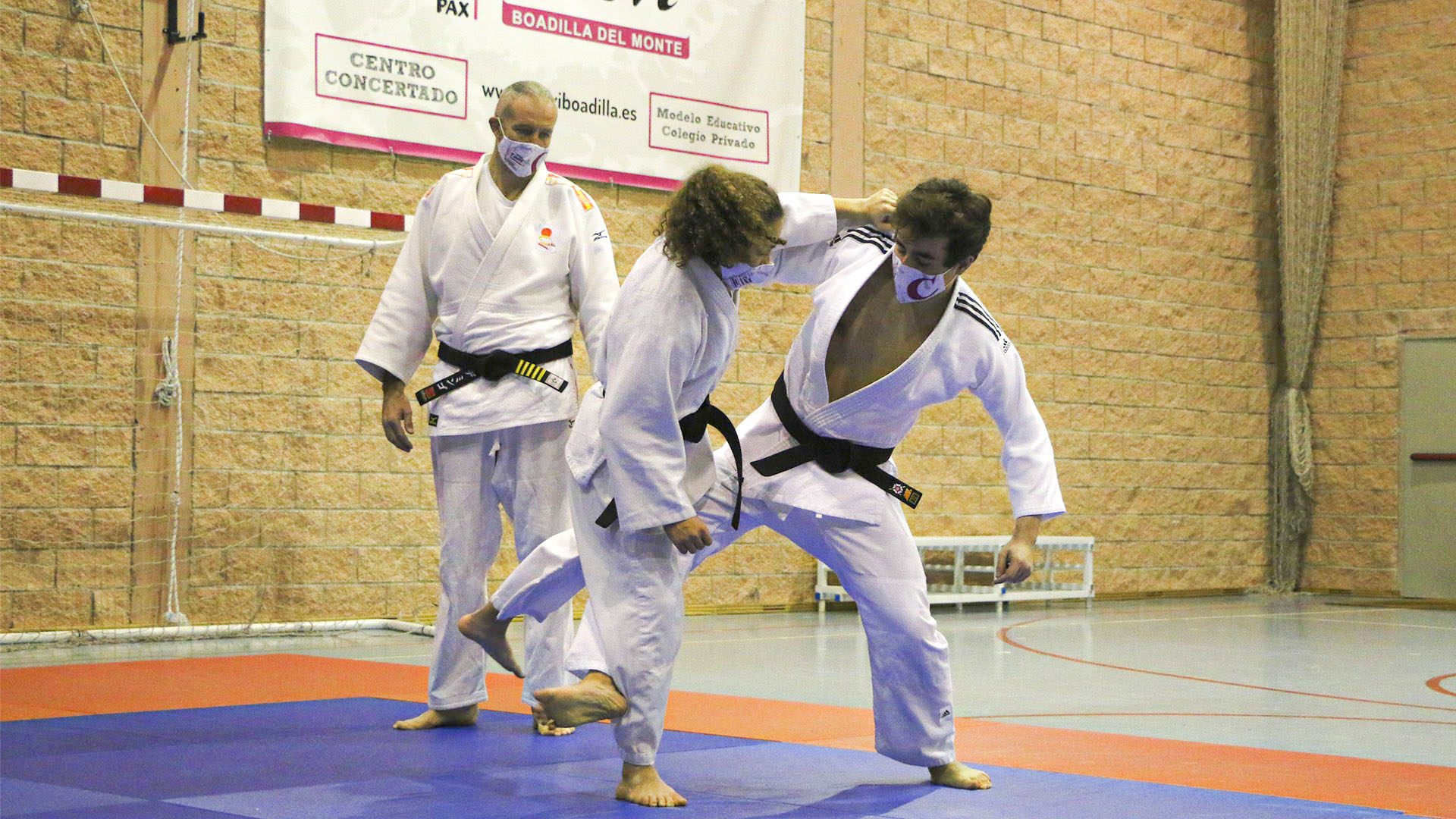Alumnos hacen una llave en clase de judo.