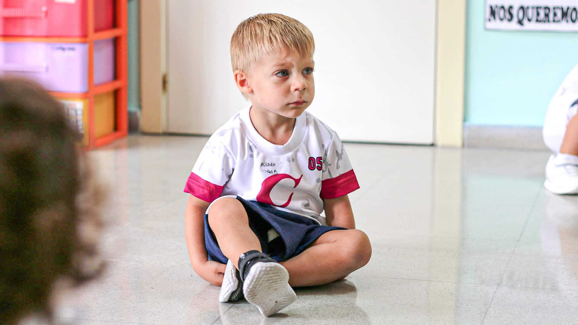 Un alumno de 2 años, sentado en el suelo observando durante el inicio de curso en Eurocolegio Casvi Boadilla.