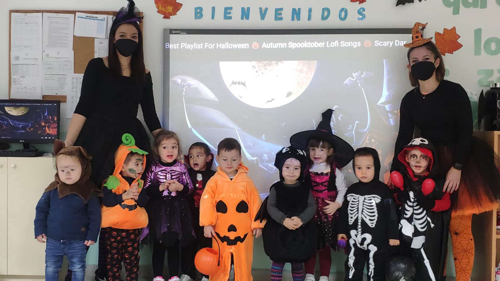 Alumnos de 2 años posan con disfraces de Halloween.