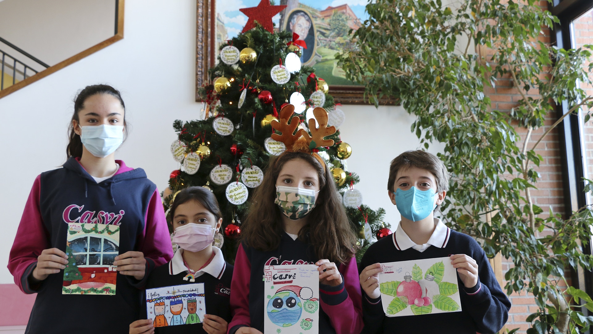 Tres niños muestran sus christmas de navidad ganadores del concurso de Casvi.