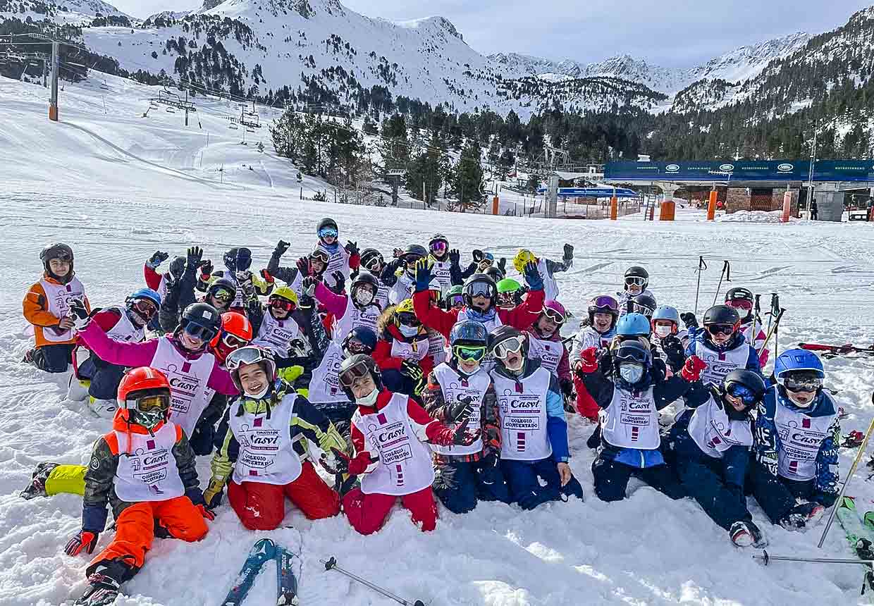 Alumnos posan levantando los palos de esquí durante la Semana Blanca en Grandvalira, Andorra.