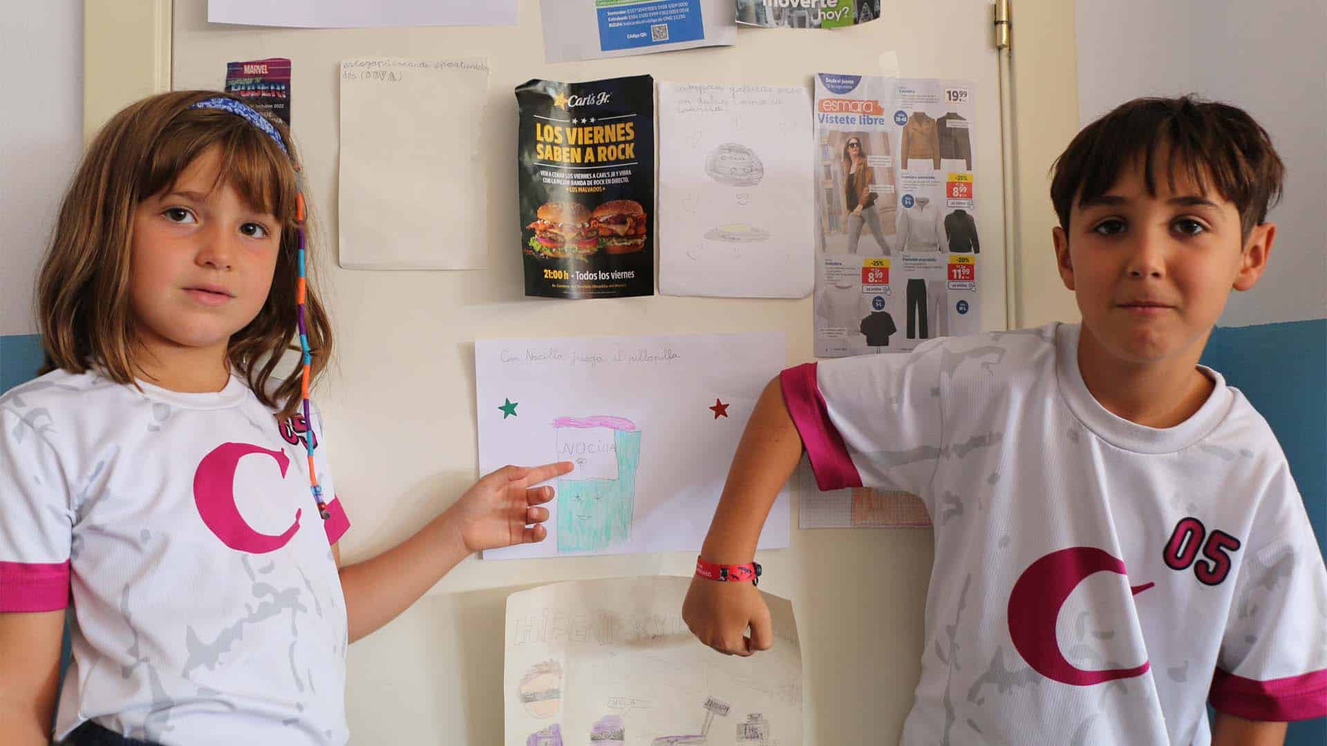 Niños mostrando su trabajo sobre publicidad